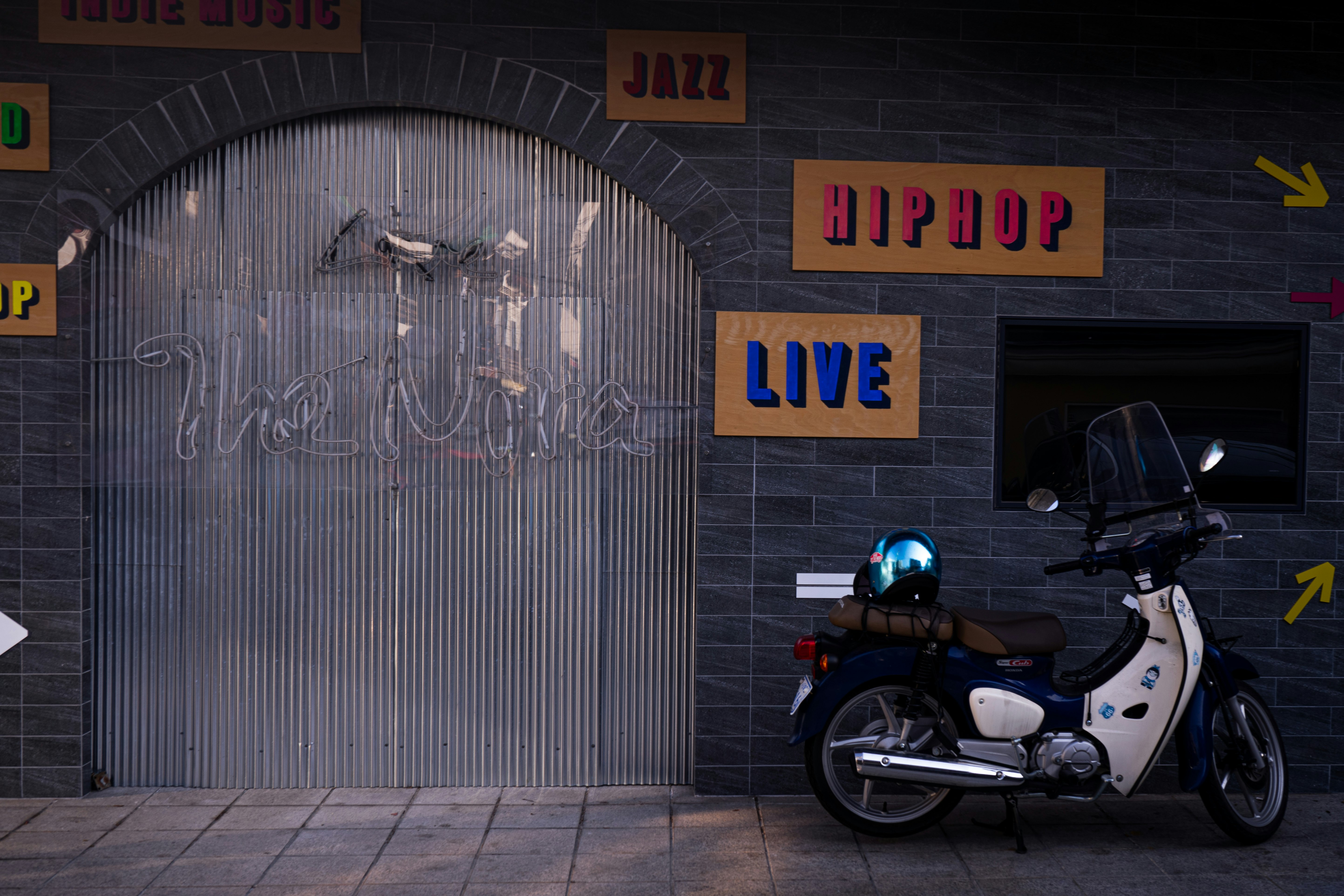 black and white motorcycle parked beside brown wall