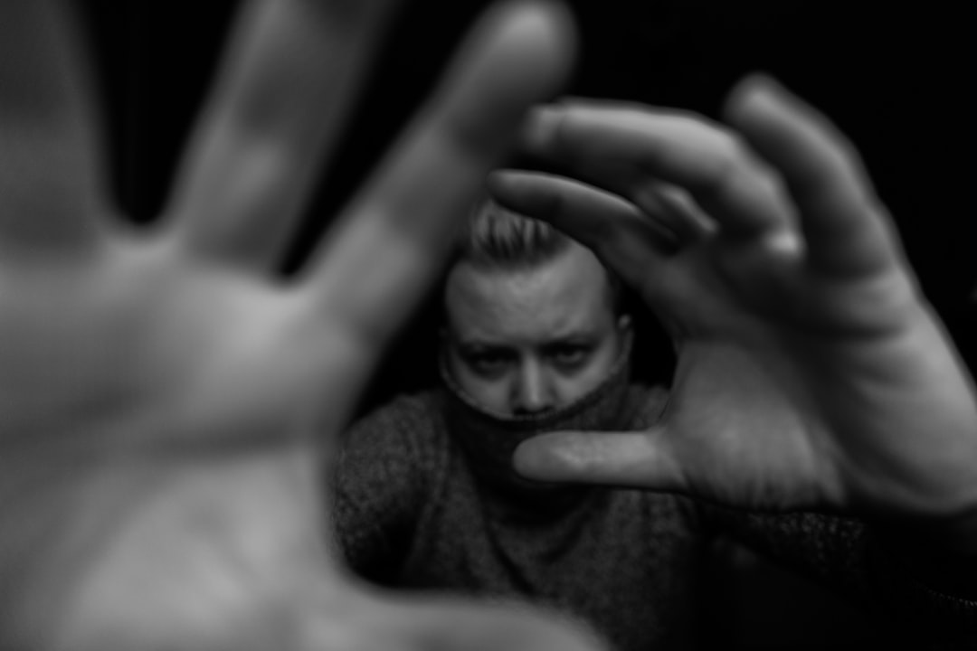 grayscale photo of woman covering her face with her hands