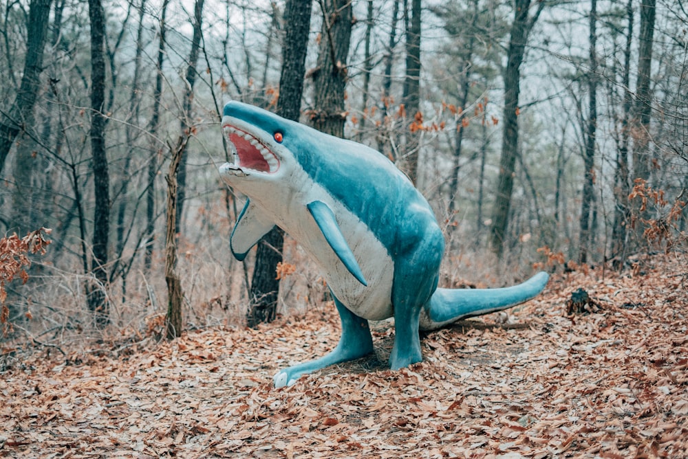 blue and white shark figurine on brown dried leaves