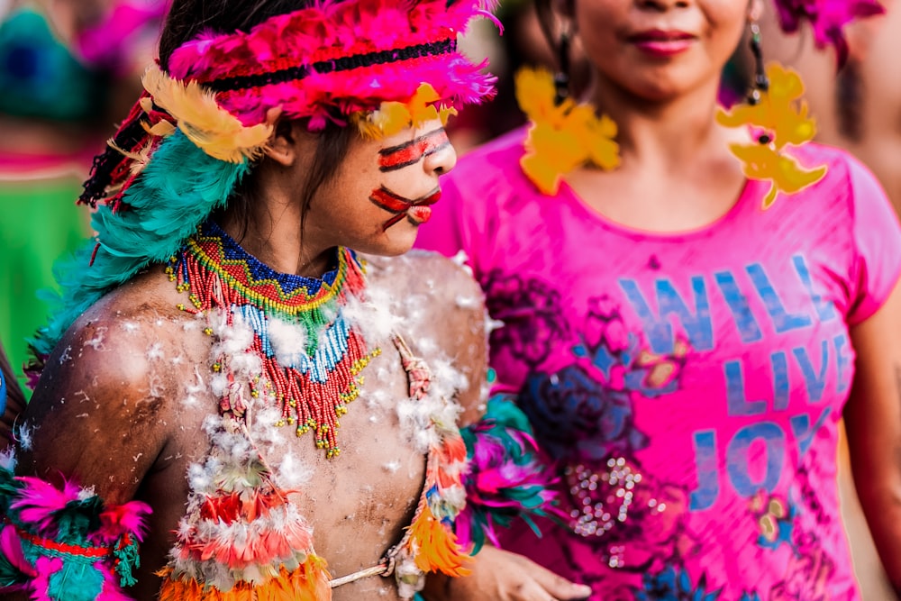 woman in pink crew neck shirt with multicolored feather headdress