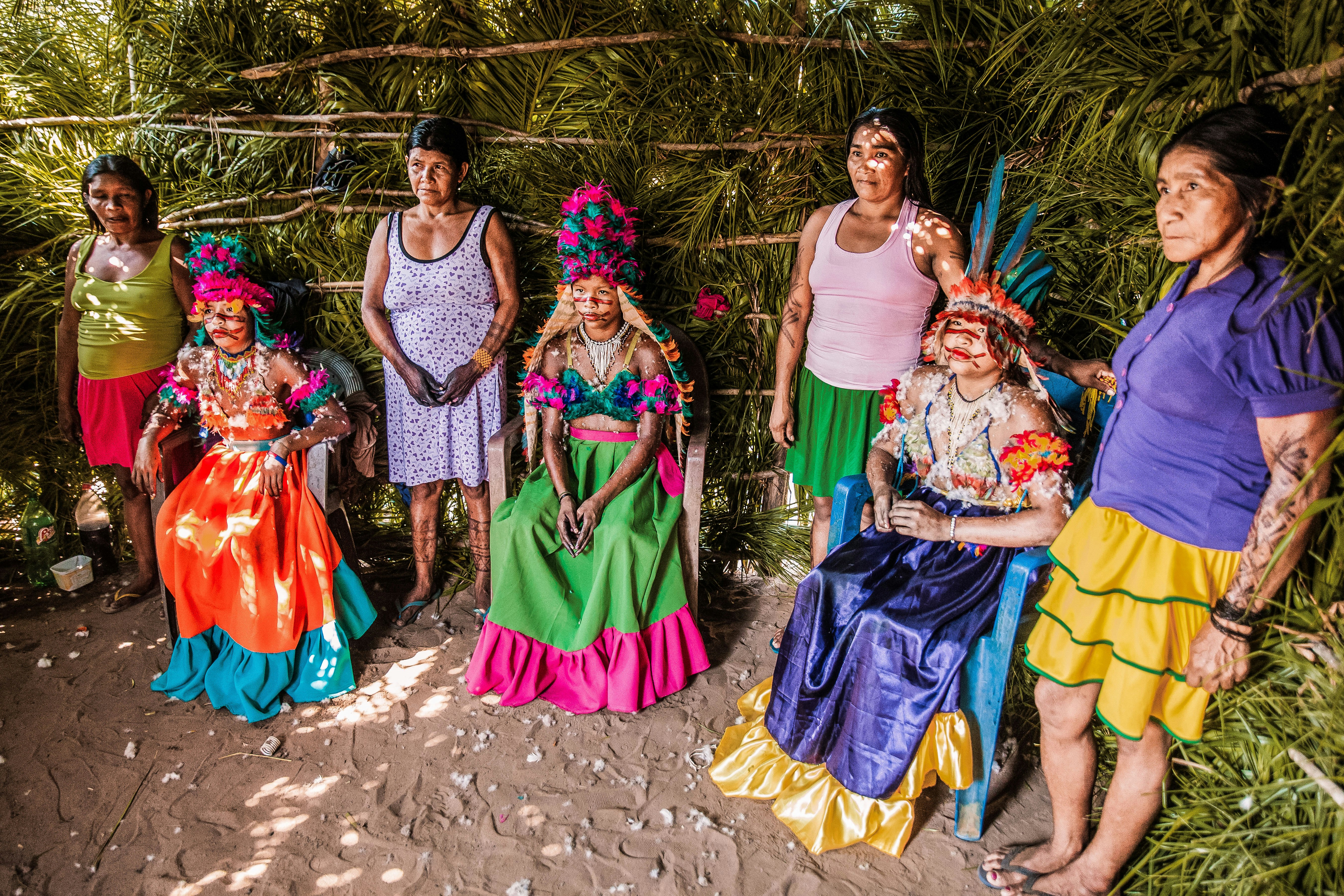 3 women in dress standing on brown sand during daytime