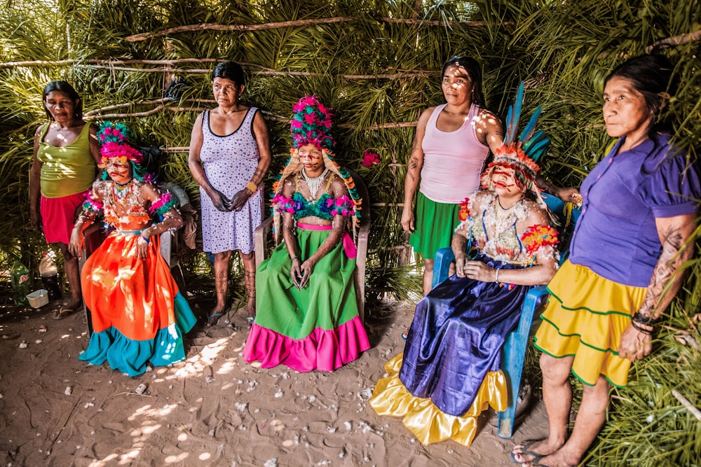 3 women in dress standing on brown sand during daytime