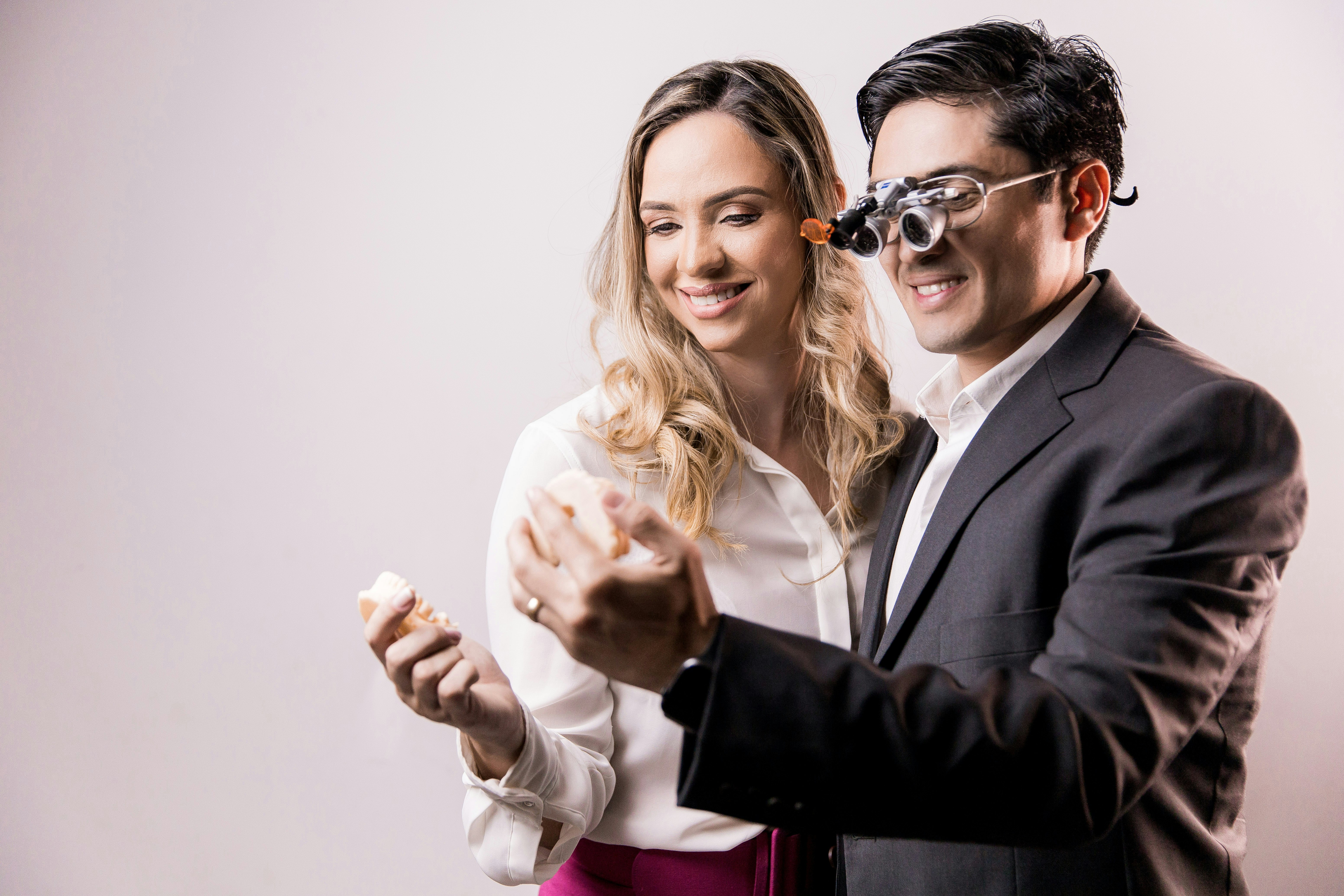 man in black suit jacket holding woman in white dress shirt