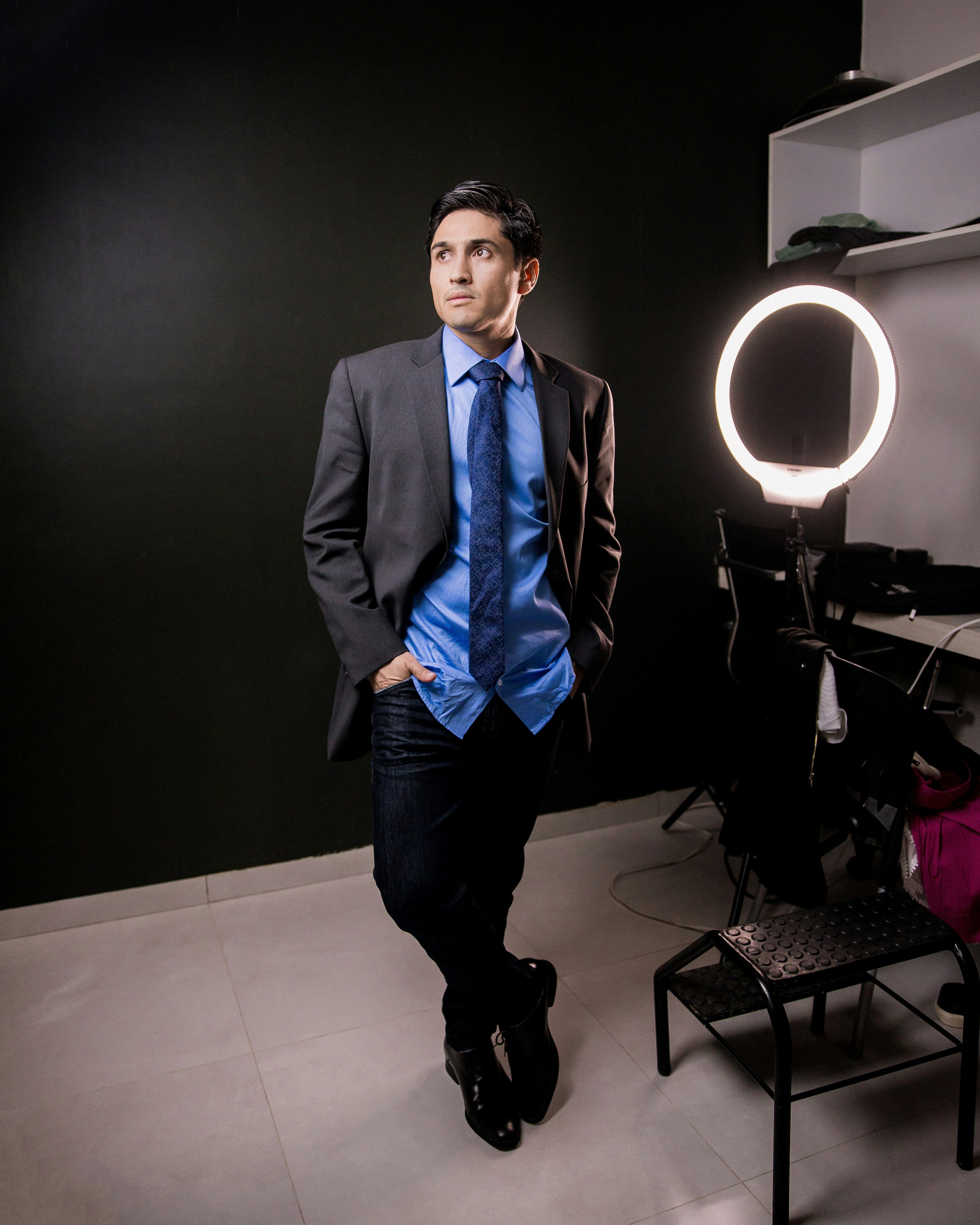 man in black suit standing near black table