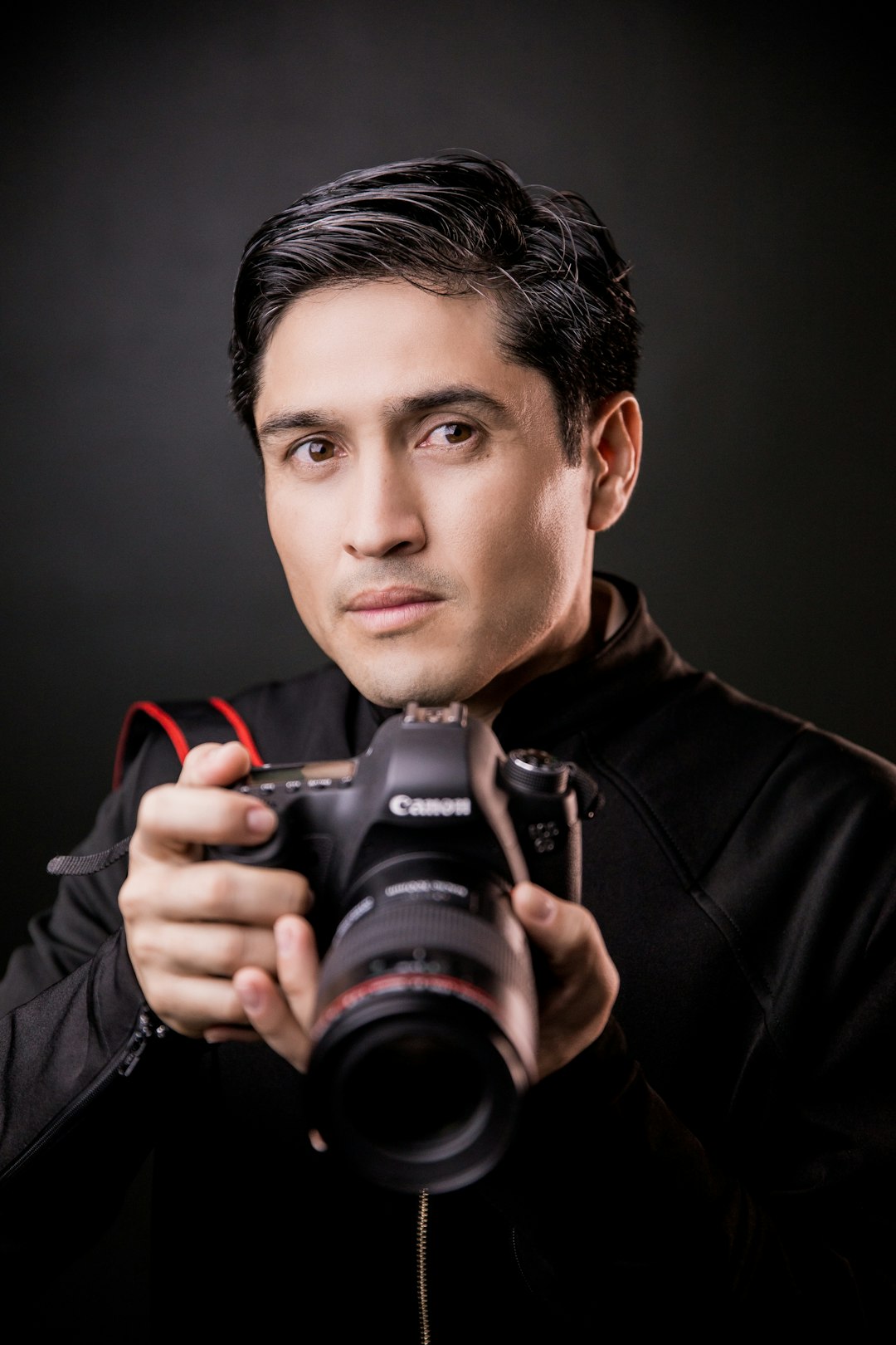 man in black leather jacket holding black nikon dslr camera