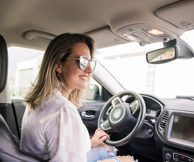 woman in white long sleeve shirt driving car