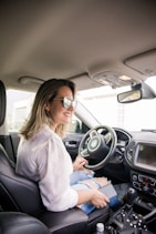 woman in white long sleeve shirt driving car
