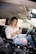 woman in white shirt and blue denim jeans sitting on car seat