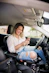 woman in white shirt and blue denim jeans sitting on car seat