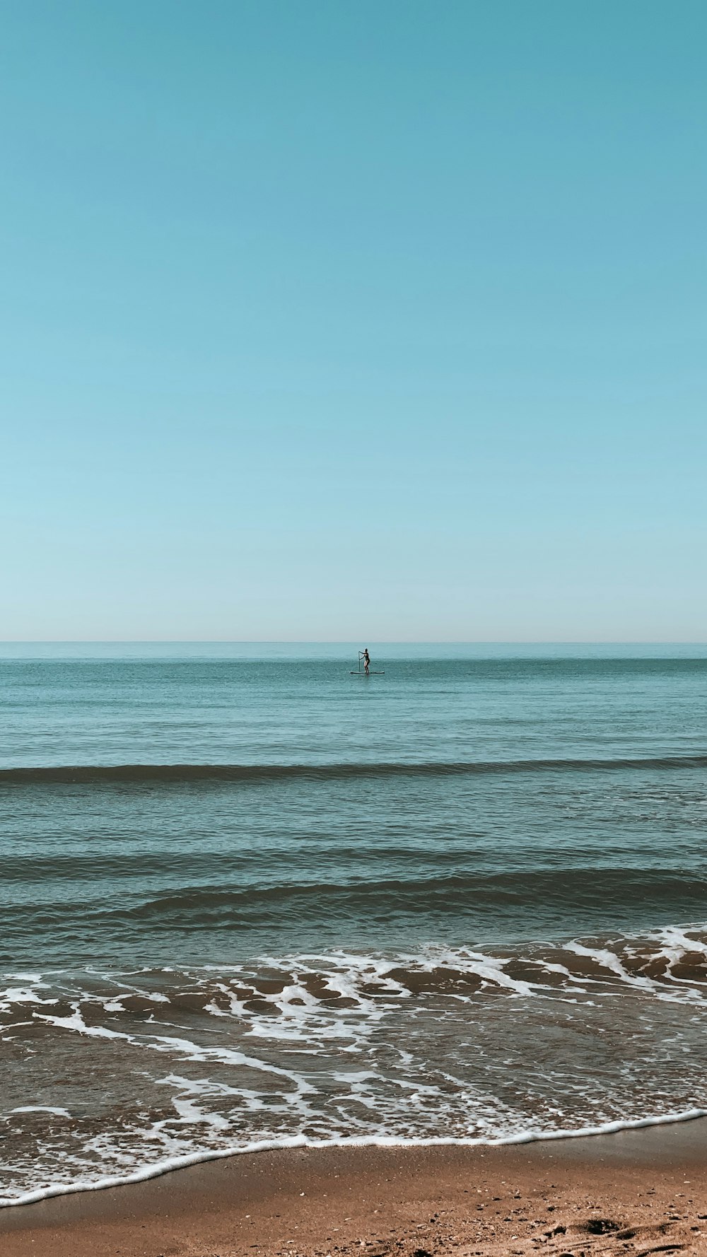 pessoa em pé na costa do mar durante o dia