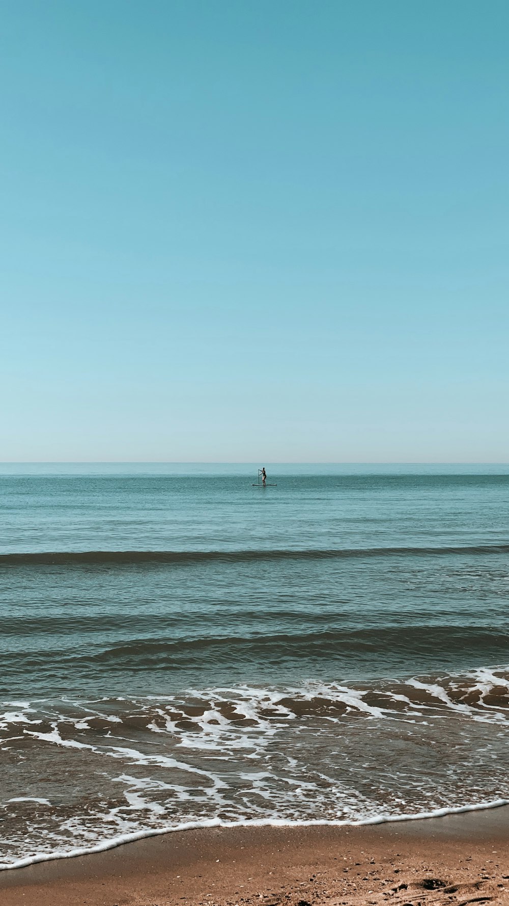 person standing on sea shore during daytime