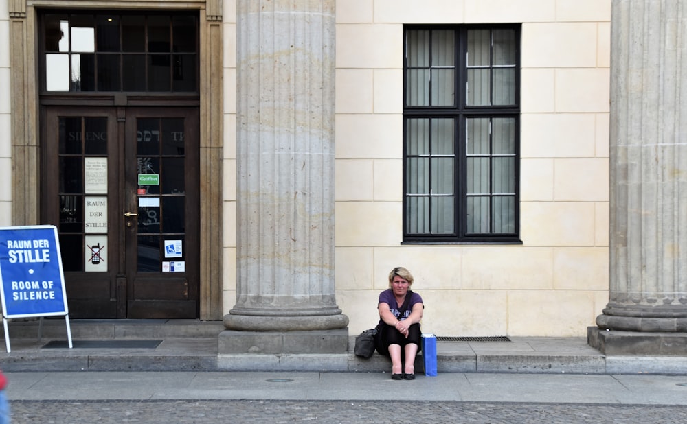 woman in blue denim jacket sitting on gray concrete bench