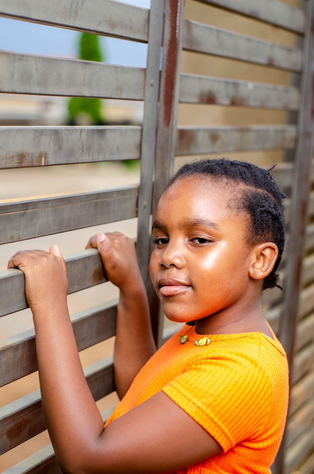 boy in yellow shirt leaning on gray metal railings