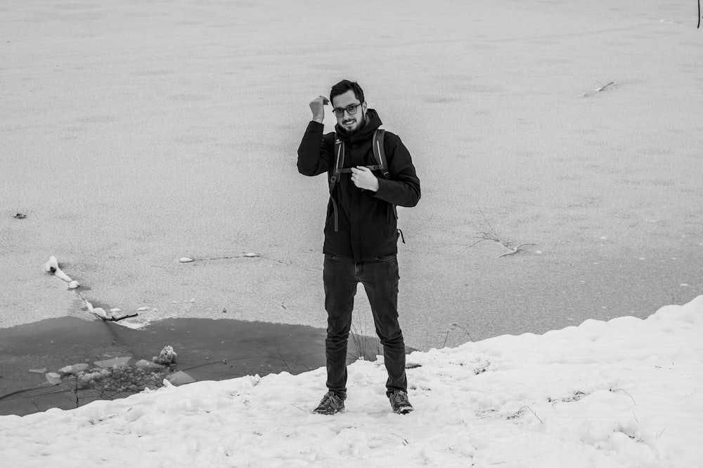 man in black jacket and pants standing on snow covered ground