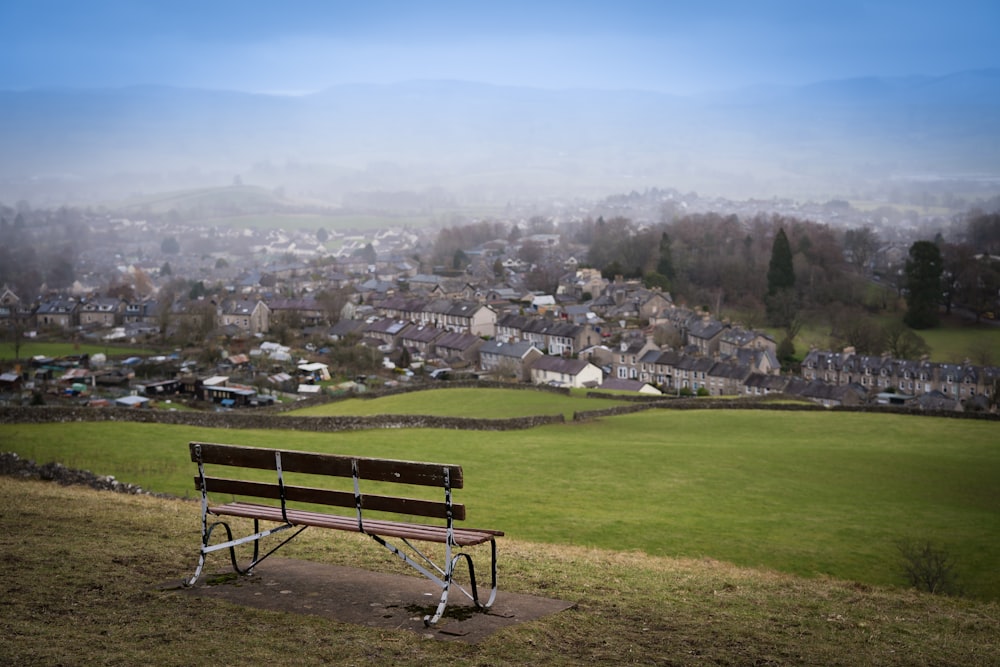 brown wooden bench on green grass field during daytime