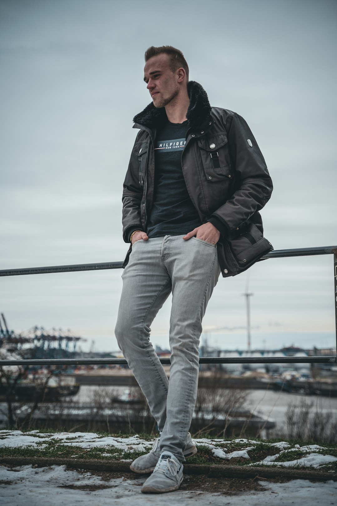 man in black leather jacket and gray pants holding black metal bar during daytime