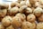 A pile of freshly baked chocolate chip cookies with a golden-brown color. The cookies appear soft and have visible dark chocolate chips scattered throughout. They are arranged closely together, likely on a tray or baking sheet.