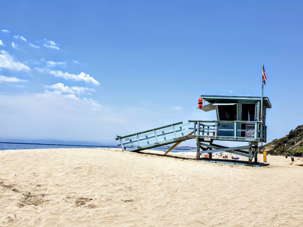 white wooden lifeguard house on beach during daytime