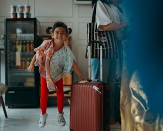 a little girl is jumping in the air with a suitcase