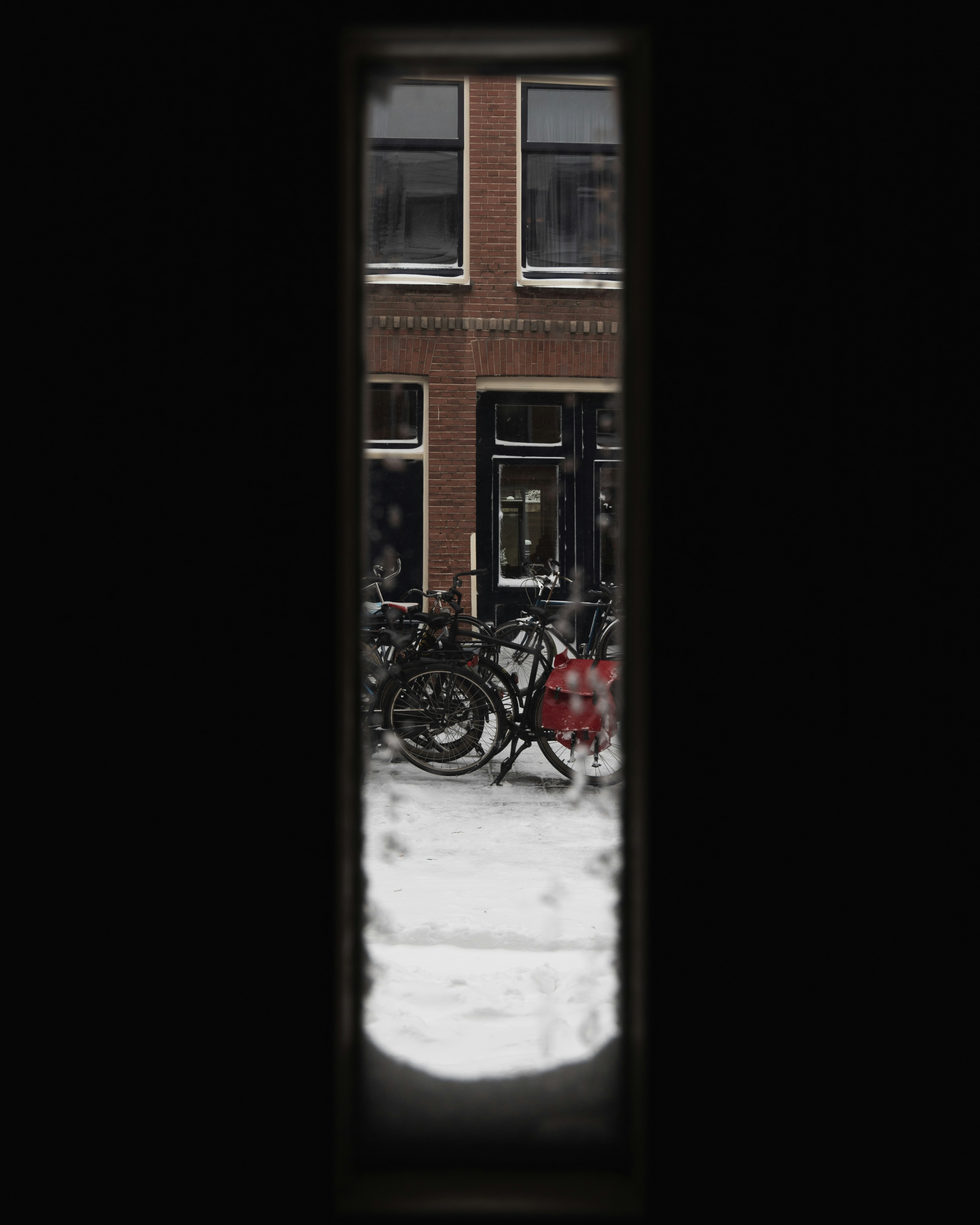 red bicycle parked beside brown concrete building during daytime