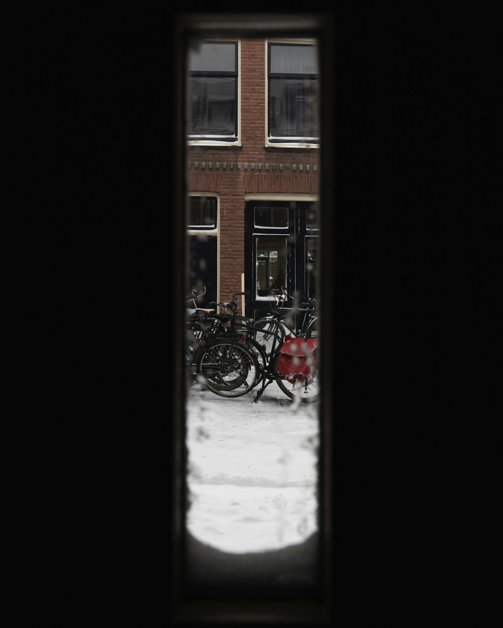 낮에는 갈색 콘크리트 건물 옆에 주차된 빨간 자전거