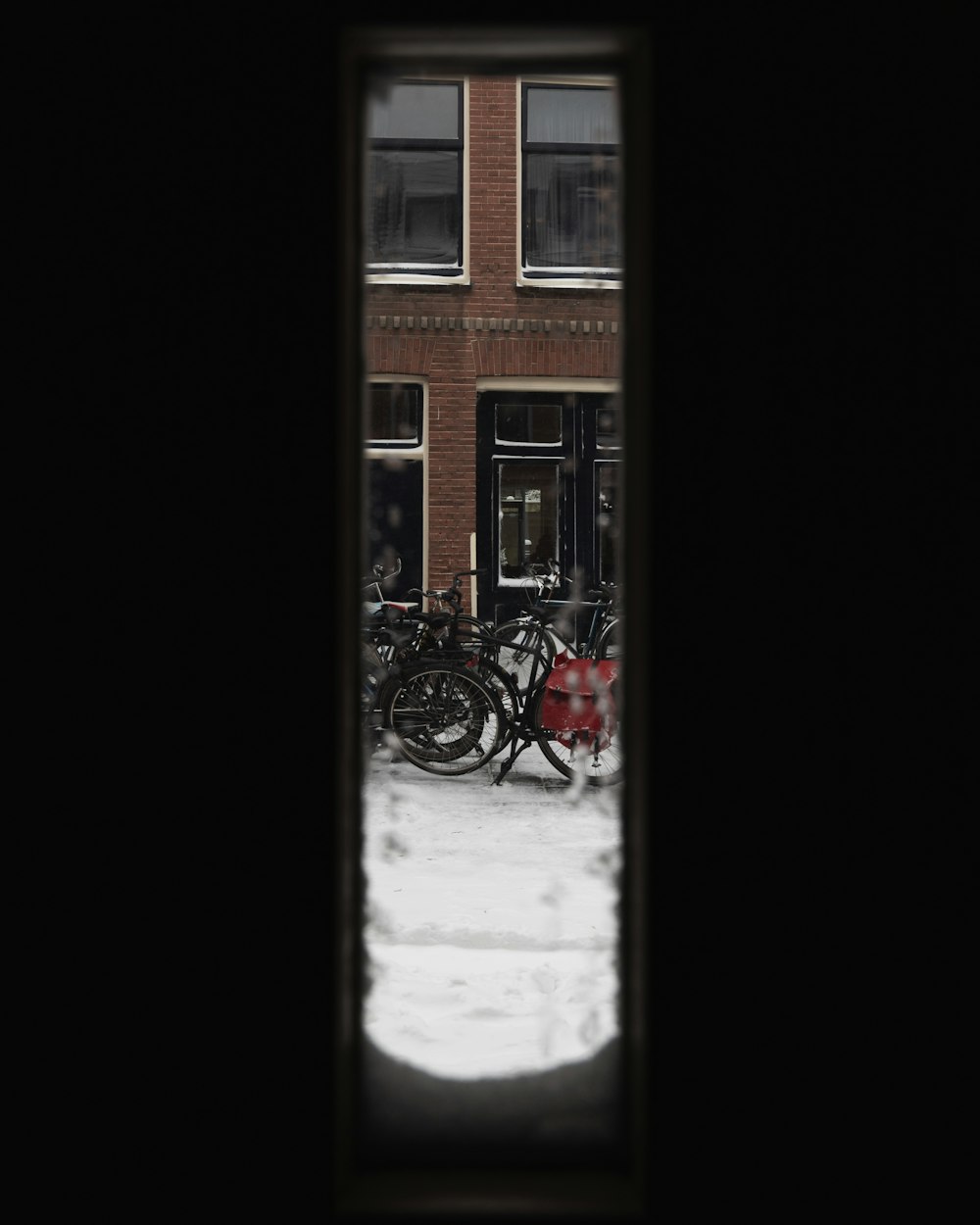 red bicycle parked beside brown concrete building during daytime