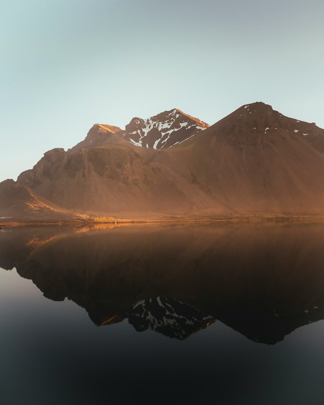 brown and white mountains near body of water during daytime