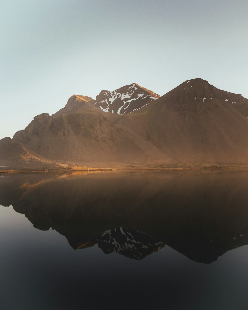 brown and white mountains near body of water during daytime