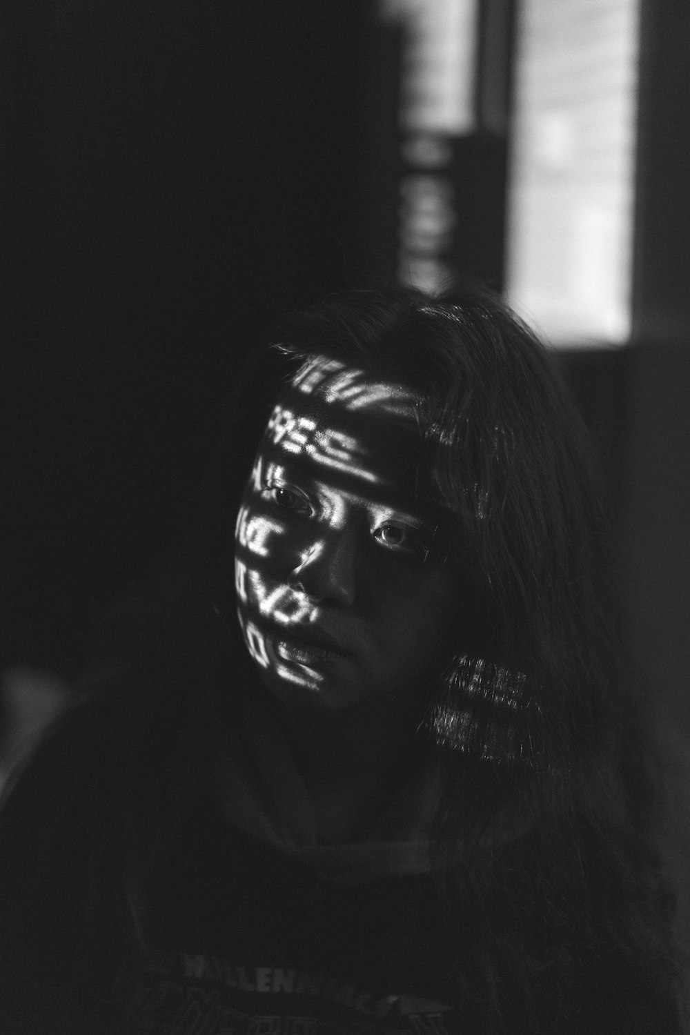 얼굴 페인트를 칠한 여성의 그레이스케일 사진