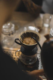 Illustration of a pour-over coffee setup with a dripper and kettle.