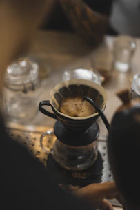 Illustration of a pour-over coffee setup with a dripper and kettle.