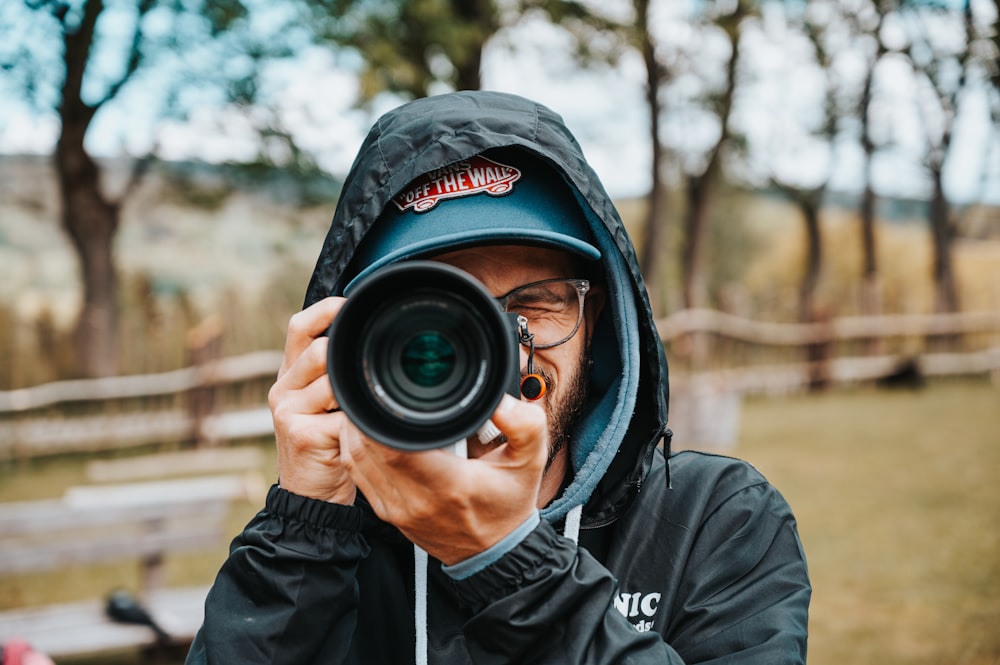 man in black hoodie taking photo