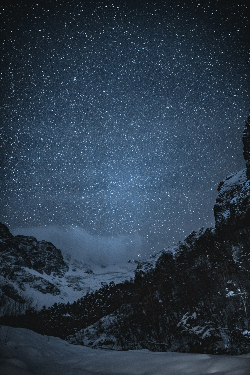 snow covered mountain under starry night