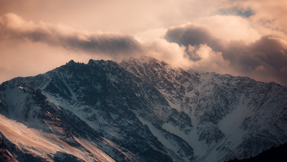 brown and white mountain under white clouds during daytime