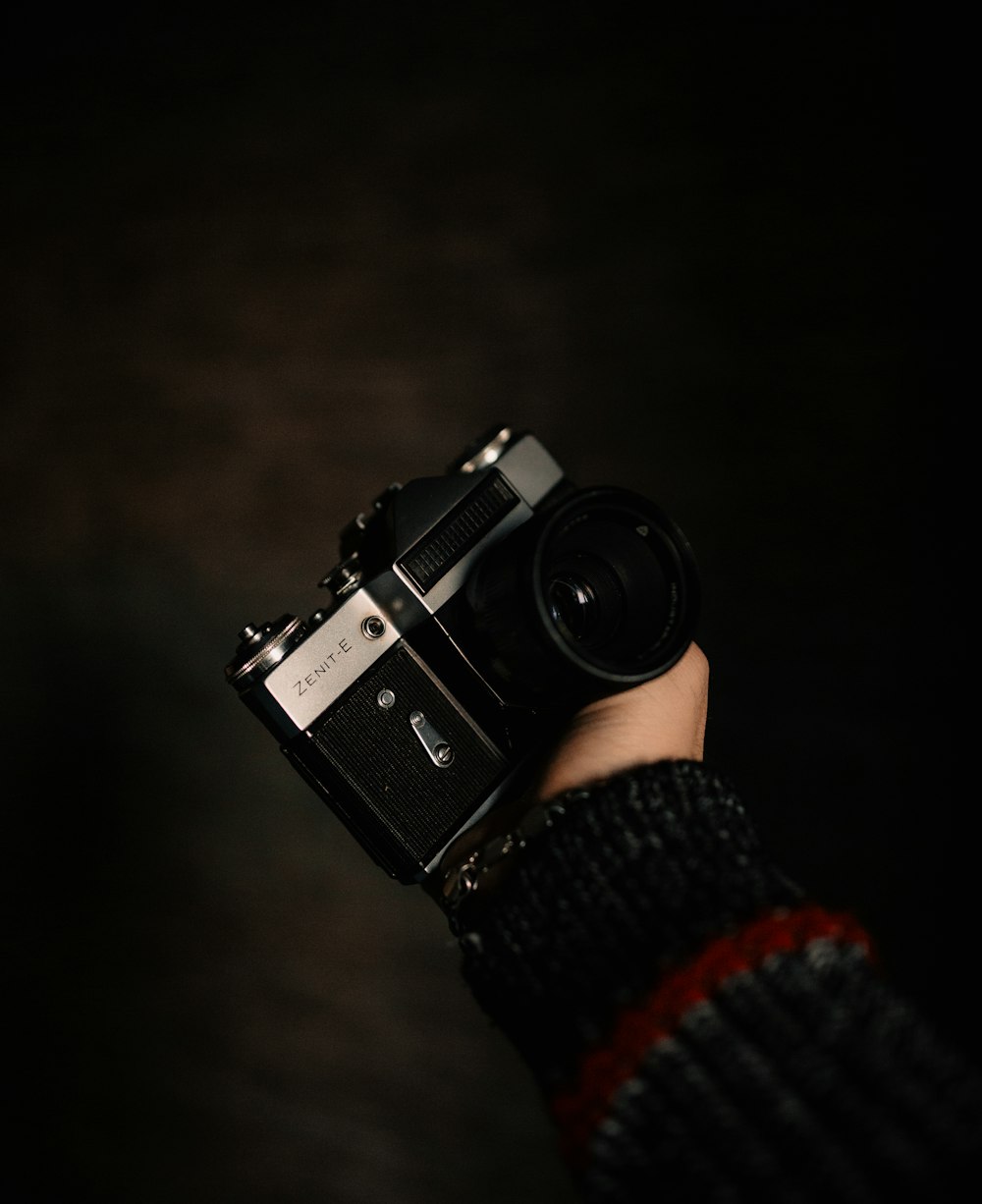 person holding black and silver dslr camera