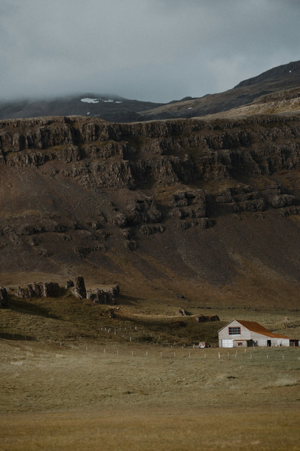 white and brown house near brown mountain during daytime