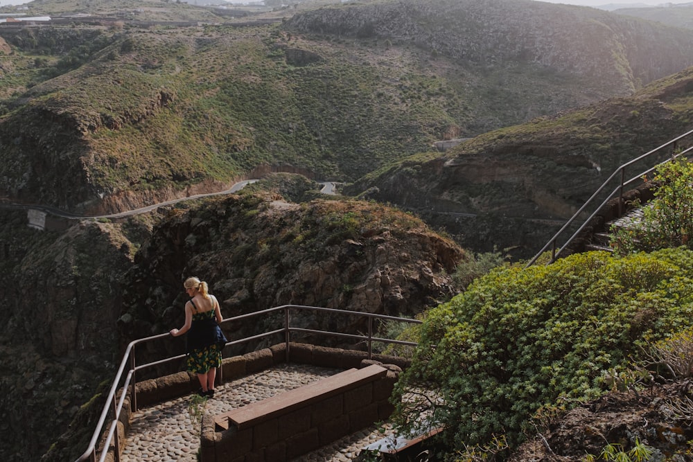 woman in black tank top sitting on brown concrete stairs during daytime