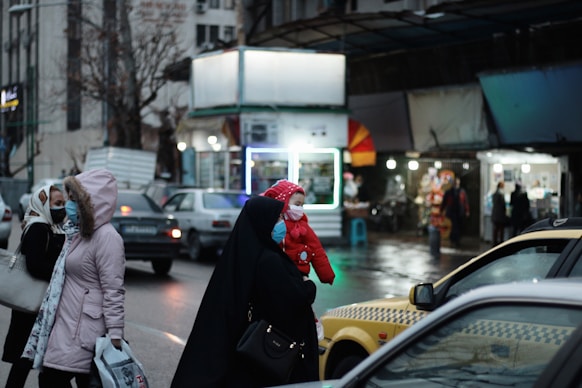 man in black hoodie and red knit cap walking on street during daytime