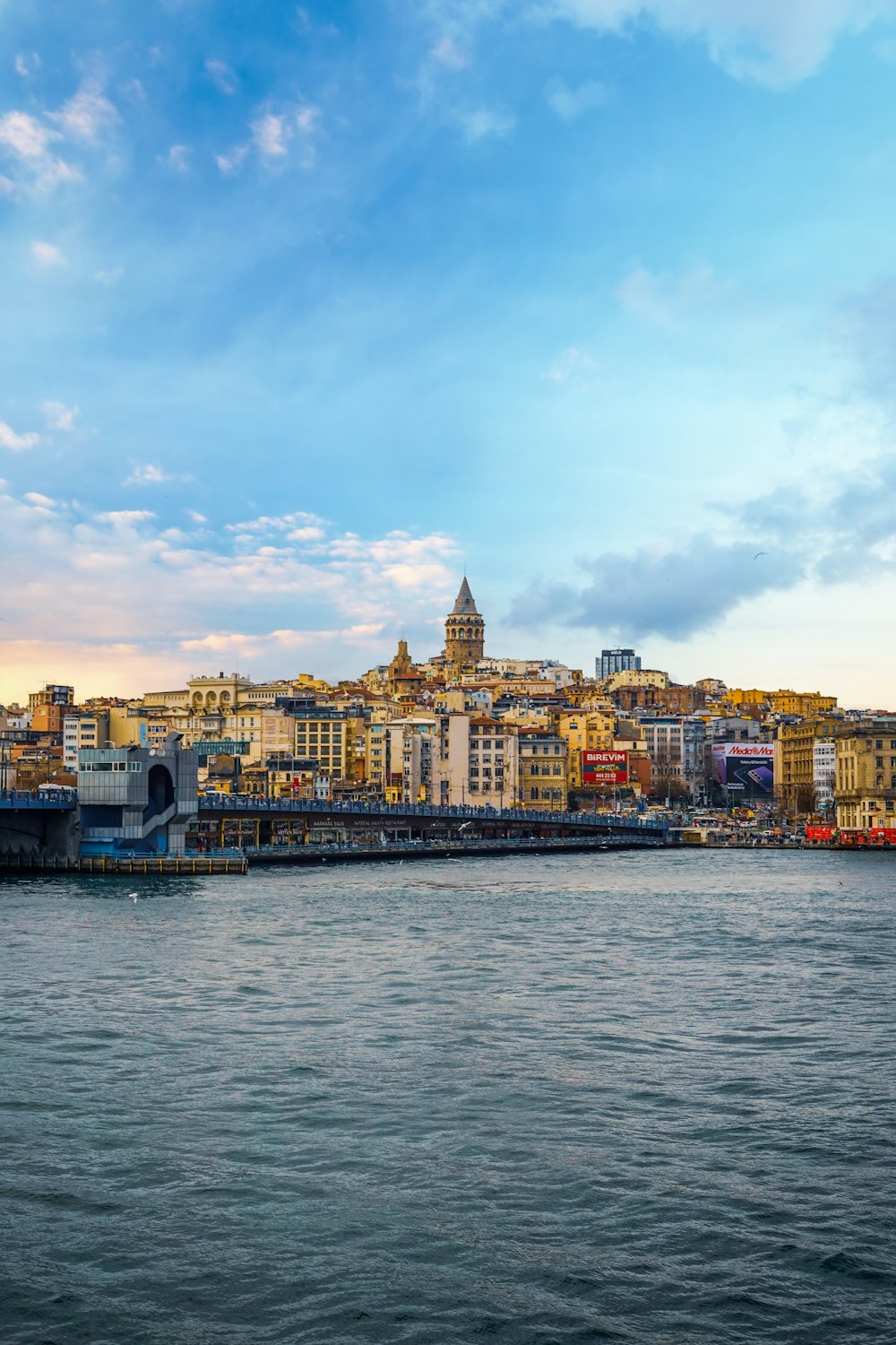 city buildings near body of water under cloudy sky during daytime