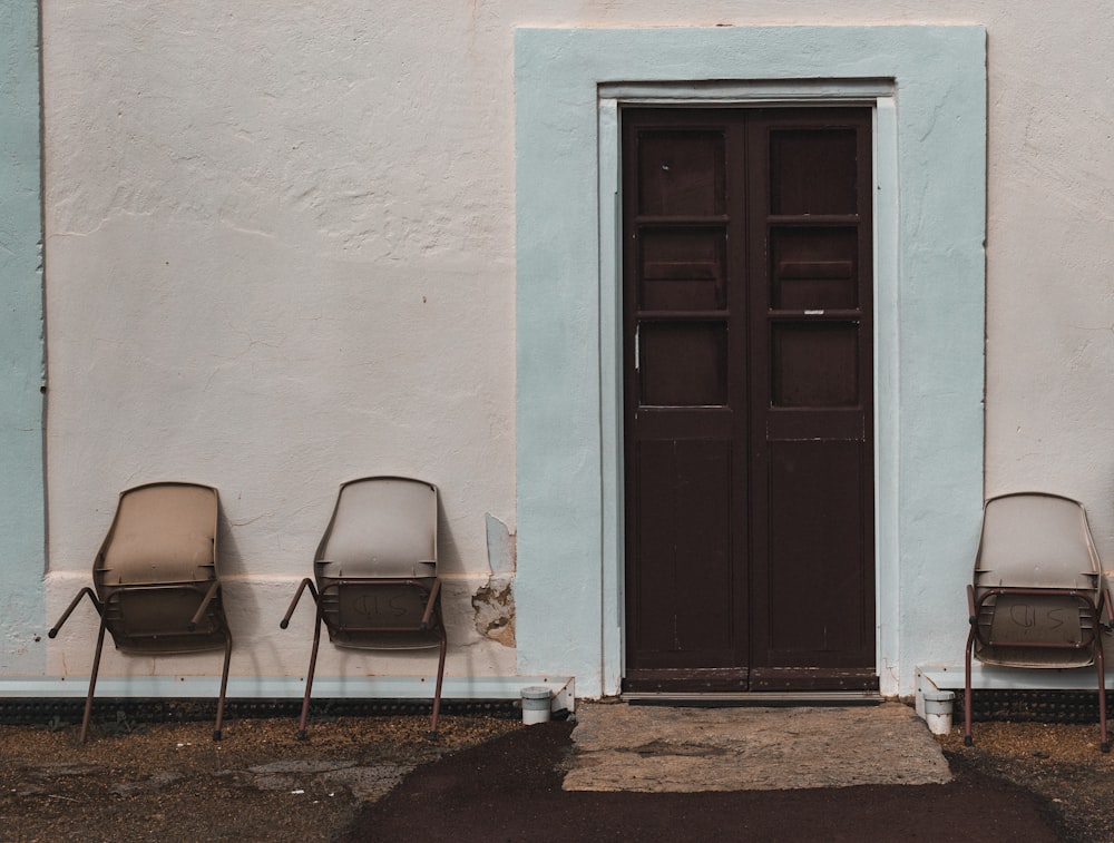 black and gray chair beside blue wooden door