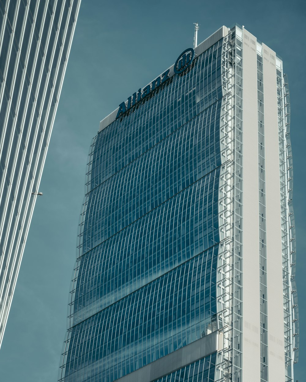 blue and white glass walled high rise building