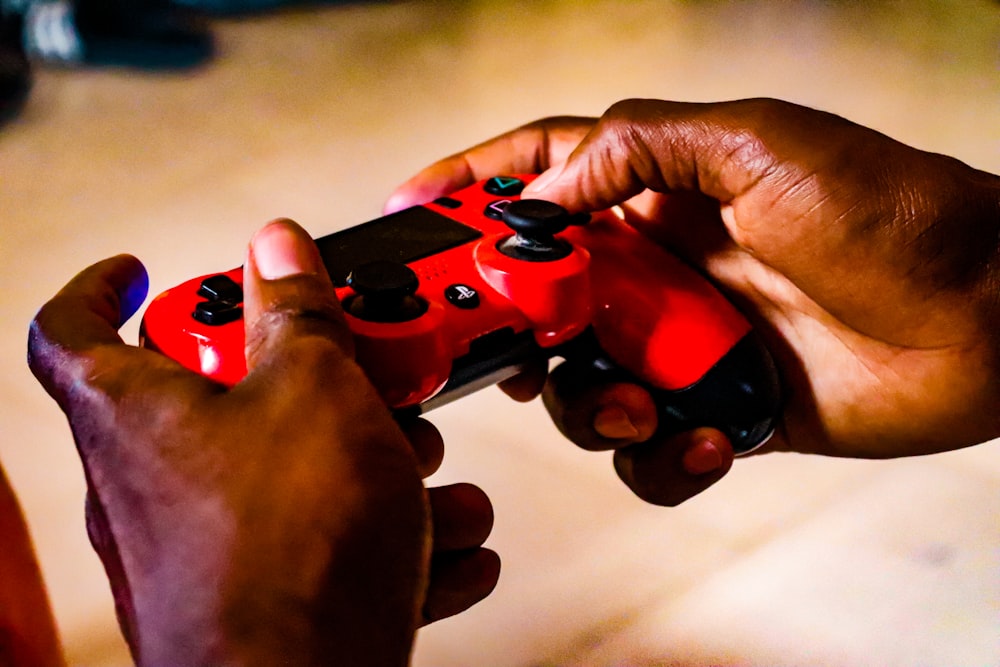 person holding red and black game controller