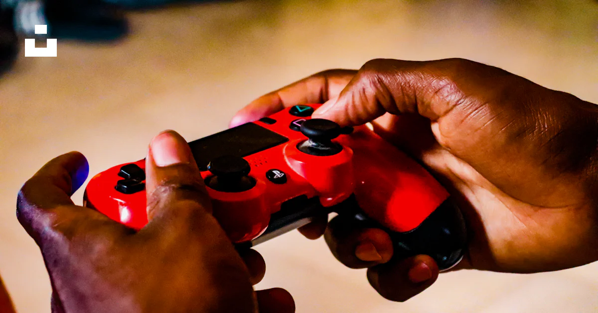 persons holding a red and black remote controllers ·... Person holding red and black game controller photo – Free Controller ...