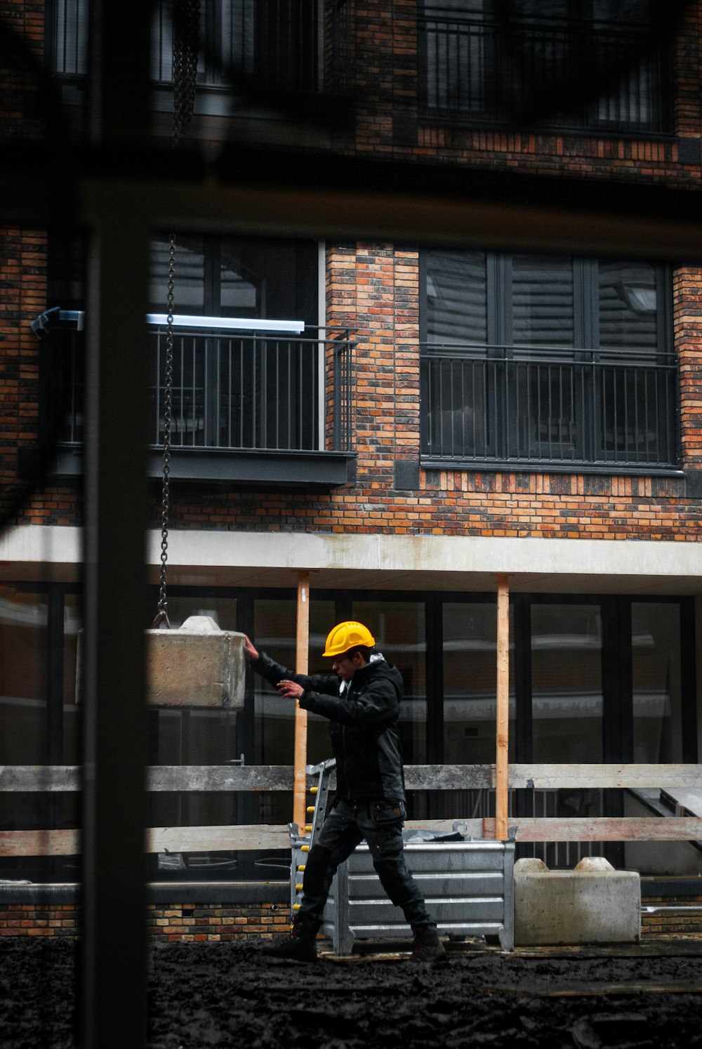 man in black jacket and yellow helmet holding black metal bar