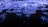 Waves of vibrant blue light ripple across a dark surface, creating a dynamic and fluid visual effect reminiscent of water or liquid textures. The intricate patterns and reflections evoke a sense of movement and energy.