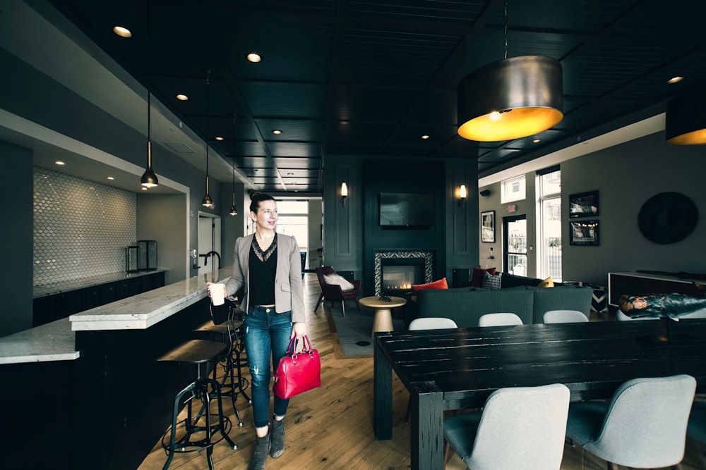 woman in white long sleeve shirt standing near brown wooden table