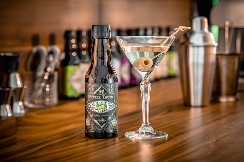 black and white labeled bottle beside clear martini glass