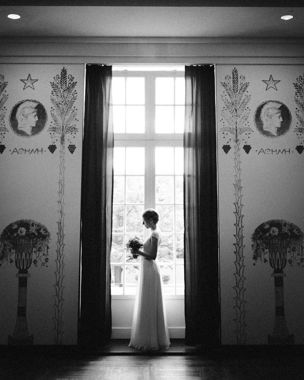 白い丸いアナログ壁掛け時計の近くの白い花柄の窓のカーテン
