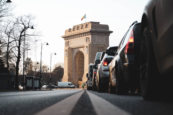 cars on road near brown concrete arch during daytime