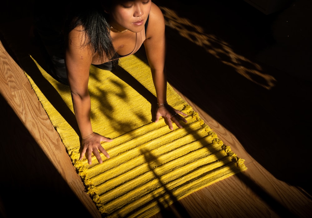 woman in yellow tank top standing on brown wooden dock during daytime